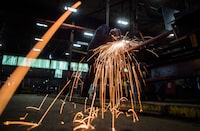 A worker uses a grinder on a steel stairs being manufactured for a high school in Redmond, Wash., at George Third & Son Steel Fabricators and Erectors, in Burnaby, B.C., on Thursday, Mar. 29, 2018. Statistics Canada says both wholesale sales and manufacturing sales fell in November.THE CANADIAN PRESS/Darryl Dyck