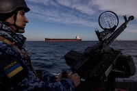 FILE PHOTO: A serviceman of Ukraine's coast guard mans a gun on a patrol boat as a cargo ship passes by in the Black Sea, amid Russia’s attack on Ukraine, February 7, 2024. REUTERS/Thomas Peter/File Photo