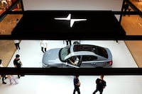FILE PHOTO: People look at a Polestar 2 electric sedan displayed in a shopping mall in Shanghai, China May 5, 2020. Picture taken May 5, 2020. REUTERS/Yilei Sun/File Photo