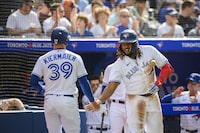 Toronto Blue Jays first baseman Vladimir Guerrero Jr. (27) celebrates with centre fielder Kevin Kiermaier (39) after Kiermaier scored on a line drive by shortstop Bo Bichette (11) during fifth inning MLB baseball action against the Atlanta Braves, in Toronto on Saturday, May 13, 2023. THE CANADIAN PRESS/Christopher Katsarov