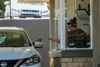 A customer pays for their food at the drive-thru of a fast-food restaurant in Los Angeles on Monday, April 1, 2024. Most fast food workers in California will be paid at least $20 an hour beginning Monday when a new law is scheduled to kick in giving more financial security to an historically low-paying profession while threatening to raise prices in a state already known for its high cost of living. (AP Photo/Damian Dovarganes)