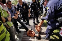 FILE - A University of Southern California protester is detained by USC Department of Public Safety officers during a pro-Palestinian occupation at the campus' Alumni Park, Wednesday, April 24, 2024, in Los Angeles. (AP Photo/Richard Vogel, File)