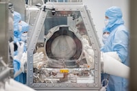 Scientists lift the lid off of the OSIRIS REx science canister after placing it inside a sealed glove box at NASA's Johnson Space Center on September 26, 2023.
Credit: Robert Markowitz