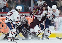 Peterborough Petes' Samual Mayer (2) defends against Kamloops Blazers' Jakub Demek (27) and Dylan Sydor (23) in front of Peterborough goalie Liam Sztuska during second period Memorial Cup hockey action, in Kamloops, B.C., on Sunday, May 28, 2023. THE CANADIAN PRESS/Darryl Dyck