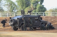 A Thai military armored vehicle takes a position with sounds of explosions and gunshots along the Moei river, under the 2nd Thai-Myanmar Friendship Bridge in Mae Sot in Thailand's Tak province Saturday, April 20, 2024. About 1,300 people have fled from eastern Myanmar into Thailand, officials said Saturday, as fresh fighting erupted near a border town that has recently been captured by ethnic guerillas. (AP Photo/Warangkana Wanichachewa)