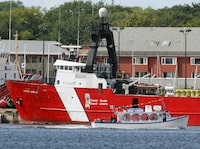 A tour boat passes the damaged Canadian Coast Guard vessel Alfred Needler in Charlottetown, P.E.I. on Sept. 2, 2003.