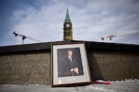 A framed portrait of former prime minister Brian Mulroney leans against the Centennial Flame on Parliament Hill  
as Canadians mourn his death at the age of 84, in Ottawa, on Friday, March 1, 2024. THE CANADIAN PRESS/Justin Tang