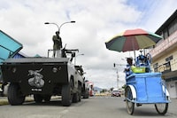 FILE - Soldiers stand on armored vehicles as they patrol the streets during a national state of emergency decreed by President Daniel Noboa to confront a wave of crime, in Portoviejo, Ecuador, Jan. 11, 2024. Ecuadorians head to the polls Sunday, April 21, 2024, in a referendum touted by Noboa as a way to crack down on criminal gangs behind a spiraling wave of violence. (AP Photo/Ariel Ochoa, File)