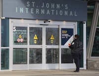 A person stands at the main entrance to St. John's International Airport Terminal is shown on January 19, 2022.&nbsp;Police in Newfoundland and Labrador say they're investigating a bomb threat made at the St. John's International Airport this morning. THE CANADIAN PRESS/Paul Daly