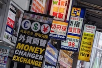 Signage for currency exchange shops is pictured along a street in central Tokyo on April 17.