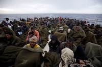 FILE - Migrants sit on the deck of the Belgian Navy vessel Godetia after they were saved at sea during a search and rescue mission in the Mediterranean Sea off the Libyan coasts, Wednesday, June 24, 2015. The UN migration agency marks a decade since the launch of the Missing Migrants Project, documenting more than 63,000 deaths around the world. More than two-thirds of victims remain unidentified highlighting the size of the crisis and the suffering of families who rarely receive definitive answers. (AP Photo/Gregorio Borgia, File)