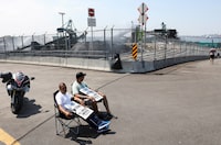 People sit as longshoremen with the International Longshore and Warehouse Union Canada (ILWU) strike outside the Port of Vancouver's Neptune Bulk Terminals in North Vancouver, British Columbia, Canada July 5, 2023.  REUTERS/Chris Helgren