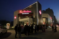 FILE PHOTO: People wait for their turn to get in Tim Hortons Cafe and Bake Shop, in Lahore, Pakistan, February 14, 2023. REUTERS/Mohsin Raza/File Photo