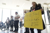 Karlene Gibson, left, holds a sign during a rally at City Hall in Regina on Wednesday, April 5, 2023. Experience Regina, the city's tourism agency, was launched in March with it posting phrases on social media that seemed to make light of the Saskatchewan capital’s name rhyming with female anatomy. THE CANADIAN PRESS/Michael Bell