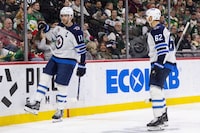 Winnipeg Jets center Adam Lowry (17) celebrates scoring a goal with Winnipeg Jets right wing Nino Niederreiter (62) during the second period of an NHL hockey game against the Minnesota Wild, Sunday, Dec. 31, 2023, in St. Paul, Minn. (AP Photo/Bailey Hillesheim)