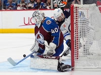Colorado Avalanche goaltender Alexandar Georgiev, front, stops a redirected shot by Winnipeg Jets center Gabriel Vilardi during the second period of Game 3 of an NHL hockey Stanley Cup first-round playoff series Friday, April 26, 2024, in Denver. (AP Photo/David Zalubowski)