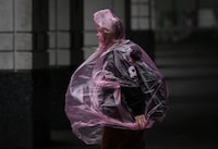 A woman wears a plastic poncho as rain falls in Vancouver, on Monday, September 25, 2023. THE CANADIAN PRESS/Darryl Dyck
