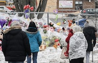 People stand next to a memorial at the site of a daycare centre in Laval, Que, Thursday, February 9, 2023, where a bus crashed into the building killing two children. THE CANADIAN PRESS/Graham Hughes