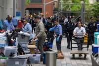 People work near police officers, where students and pro-Palestinian supporters were removed after days of encampment, outside of New York University (NYU) campus, amid the ongoing conflict in Gaza between Israel and the Palestinian Islamist group Hamas, in New York City, U.S., May 3, 2024. REUTERS/Carlos Barria