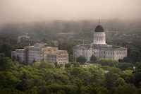 FILE - The morning fog lifts beyond the Burton M. Cross Building, left, and the State House, Wednesday, June 21, 2023, in Augusta, Maine. Maine Gov. Janet Mills has signed into law a bill Friday, April 12, 2024, restricting paramilitary training in response to a neo-Nazi who wanted to create a training center for a “blood tribe.” (AP Photo/Robert F. Bukaty, File)