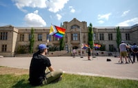 A person holds a pride flag during a Pride flag raising ceremony in Saskatoon on Thursday, June 1, 2023. A Saskatchewan judge is to hear today an injunction application that seeks to halt the province's pronoun policy affecting children at school. THE CANADIAN PRESS/Heywood Yu
