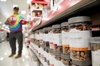 In this Friday, Nov. 16, 2018, photo, a line of mixed treats containers are seen as a shopper pulls an item from the shelf at a Target store in Edison, N.J.
