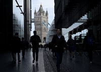 FILE PHOTO: People walk through the 'More London' business district with Tower Bridge seen behind in London, Britain, March 16, 2023. REUTERS/Toby Melville