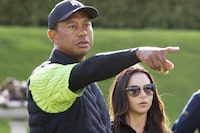 FILE - Tiger Woods, left, and Erica Herman appear on the 18th green during the JP McManus Pro-Am at Adare Manor, Limerick, Ireland, July, 4, 2022. Herman, the ex-girlfriend of golf superstar Woods, has dropped her $30 million lawsuit against the trust that owns his $54 million Florida mansion. (AP Photo/Peter Morrison, File)