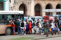 FILE PHOTO: People gather at a bus stop as the government announced it will hike the retail price of its 94 octane gasoline from 30 to 156 pesos per litre beginning February 1, in Havana, Cuba January 11, 2024. REUTERS/Yander Zamora/File Photo