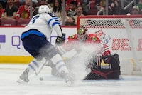 Chicago Blackhawks goaltender Petr Mrazek, right, makes a save against Winnipeg Jets center Sean Monahan, left, during the third period of an NHL hockey game Friday, Feb. 23, 2024, in Chicago. (AP Photo/Erin Hooley)