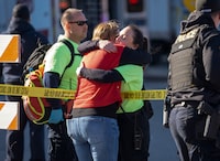 A hug over police tape after shots were fired near the Kansas City Super Bowl victory parade in Kansas City, Mo., Feb. 14, 2024. As gunshots rang out, a Super Bowl celebration dissolved into chaos; many attendees said it was hard to know where to go when gunfire broke out in Kansas City, Mo. (Christopher Smith/The New York Times)