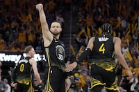 Golden State Warriors guard Stephen Curry (30) reacts after making a 3-point basket against the Sacramento Kings, between guards Donte DiVincenzo (0) and Moses Moody (4) during the second half of Game 3 of an NBA basketball first-round playoff series in San Francisco, Thursday, April 20, 2023. (AP Photo/Jeff Chiu)
