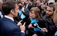 FILE PHOTO: French President Emmanuel Macron talks to a person opposed to the pension reform, in Selestat, eastern France, April 19, 2023. Ludovic Marin/Pool via REUTERS