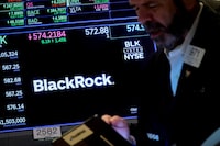 FILE PHOTO: A trader works as a screen displays the trading information for BlackRock on the floor of the New York Stock Exchange (NYSE) in New York City, U.S., October 14, 2022. REUTERS/Brendan McDermid//File Photo