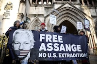 Supporters of Julian Assange display signs and a banner, outside the Royal Courts of Justice in London, Britain December 10, 2021. REUTERS/Henry Nicholls/File Photo
