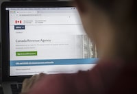 A person looks at a Canada Revenue Agency homepage in Montreal, Sunday, August 16, 2020. The federal taxpayers' watchdog says complaints to his office spiked in the hours after he went public with concerns about how the Canada Revenue Agency locked users out of their online accounts. THE CANADIAN PRESS/Graham Hughes