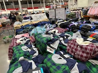 Shoppers peruse clothing on display in a Costco warehouse Wednesday, March 6, 2024, in Sheridan, Colo.