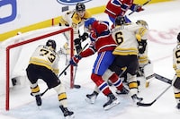 Montreal Canadiens' Johnathan Kovacevic (26) scores between Boston Bruins' Charlie McAvoy (73) and Mason Lohrei (6) during the third period of an NHL hockey game Saturday, Nov. 18, 2023, in Boston. (AP Photo/Michael Dwyer)