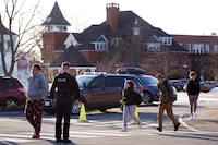 Students are released from school, under watch by local police, outside Thornton Academy following police activity in the area, Friday, Feb. 9, 2024, in Saco, Maine. Police in a Saco asked residents to shelter in place Friday afternoon while they searched for suspects after an exchange of gunfire and vehicle crash at a busy intersection spurred a brief citywide school lockdown.  (AP Photo/Charles Krupa)