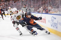 Chicago Blackhawks' Lukas Reichel (27) looks for the puck against Edmonton Oilers' Cody Ceci (5) during first period NHL hockey action in Edmonton, Thursday, Jan. 25, 2024.  THE CANADIAN PRESS/Amber Bracken
