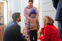 A 7-year-old Ukrainian boy, who is the first child released under a new mechanism Qatar has set up with the goal of repatriating children from Russia to Ukraine, stands with his grandmother while interacting with Russia's Commissioner for Children's Rights, Maria Lvova-Belova and a Qatari diplomat in this handout image taken at Qatar's embassy in Moscow, Russia October 13, 2023. Qatar's Ministry of Foreign Affairs/Handout via REUTERS