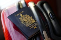 A Canadian passport sits on a suitcase in Ottawa on Tuesday, Jan. 17, 2023. Social Development Minister Karina Gould says Service Canada has "virtually eliminated" the backlog of thousands of passport applications. THE CANADIAN PRESS/Sean Kilpatrick