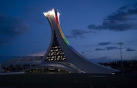 Quebec Tourism Minister Caroline Proulx says the provincial government will spend $870 million to replace the decaying roof of Montreal's Olympic Stadium. The Olympic Stadium is lit to the colours of the rainbow in solidarity with health-care workers in Montreal, on Monday, April 6, 2020. THE CANADIAN PRESS/Paul Chiasson