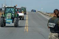 Hundreds of farmers drove their tractors and other farm vehicles through the Monteregie to Vaudreuil-Dorion creating traffic headaches west of Montreal on Wednesday, April 10, 2024. The farmers are protesting that production costs have doubled or tripled and high interest rates make covering expenses even harder.  THE CANADIAN PRESS/Peter McCabe