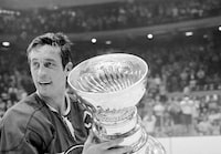 Montreal Canadiens team captain Jean Beliveau holds the Stanley Cup trophy after his team's 3-2 victory over the Chicago Black Hawks in the NHL playoff game in Chicago, Ill., Tuesday, May 18, 1971. Quebec City police are investigating after a cherished photo signed by Montreal Canadiens legend Béliveau was reported stolen from the Quebec International Pee-Wee Hockey Tournament museum. THE CANADIAN PRESS/AP