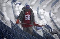 A worker helps remove snow from Highmark Stadium in Orchard Park, N.Y., Sunday Jan. 14, 2024. A potentially dangerous snowstorm that hit the Buffalo region on Saturday led the NFL to push back the Bills wild-card playoff game against the Pittsburgh Steelers from Sunday to Monday. New York Gov. Kathy Hochul and the NFL cited public safety concerns for the postponement, with up to 2 feet of snow projected to fall on the region over a 24- plus hour period. (AP Photo/ Jeffrey T. Barnes)