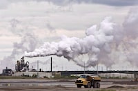 By betting that it can solve its emissions problem with carbon capture and storage technology, Canada's oil and gas industry risks sadding itself with expensive stranded assets, a new report argues. A dump truck works near the Syncrude oil sands extraction facility near the city of Fort McMurray, Alberta on Sunday June 1, 2014.  THE CANADIAN PRESS/Jason Franson