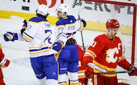 Buffalo Sabres forward JJ Peterka (77) celebrates his goal with teammate forward Tage Thompson (72) as Calgary Flames forward Mikael Backlund (11) skates away during third period NHL hockey action in Calgary, Alta., Sunday, March 24, 2024. THE CANADIAN PRESS/Jeff McIntosh