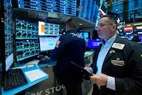 Trader Edward Curran, right, works on the floor of the New York Stock Exchange, Wednesday, Nov. 1.