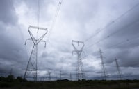 Ontario is rolling out an energy conservation program that will pay residents with smart thermostats to lower their air conditioning during certain periods in the summer. Power lines are seen against cloudy skies near Kingston, Ont. , Wednesday, Sept. 7, 2022 in Ottawa. THE CANADIAN PRESS/Adrian Wyld
